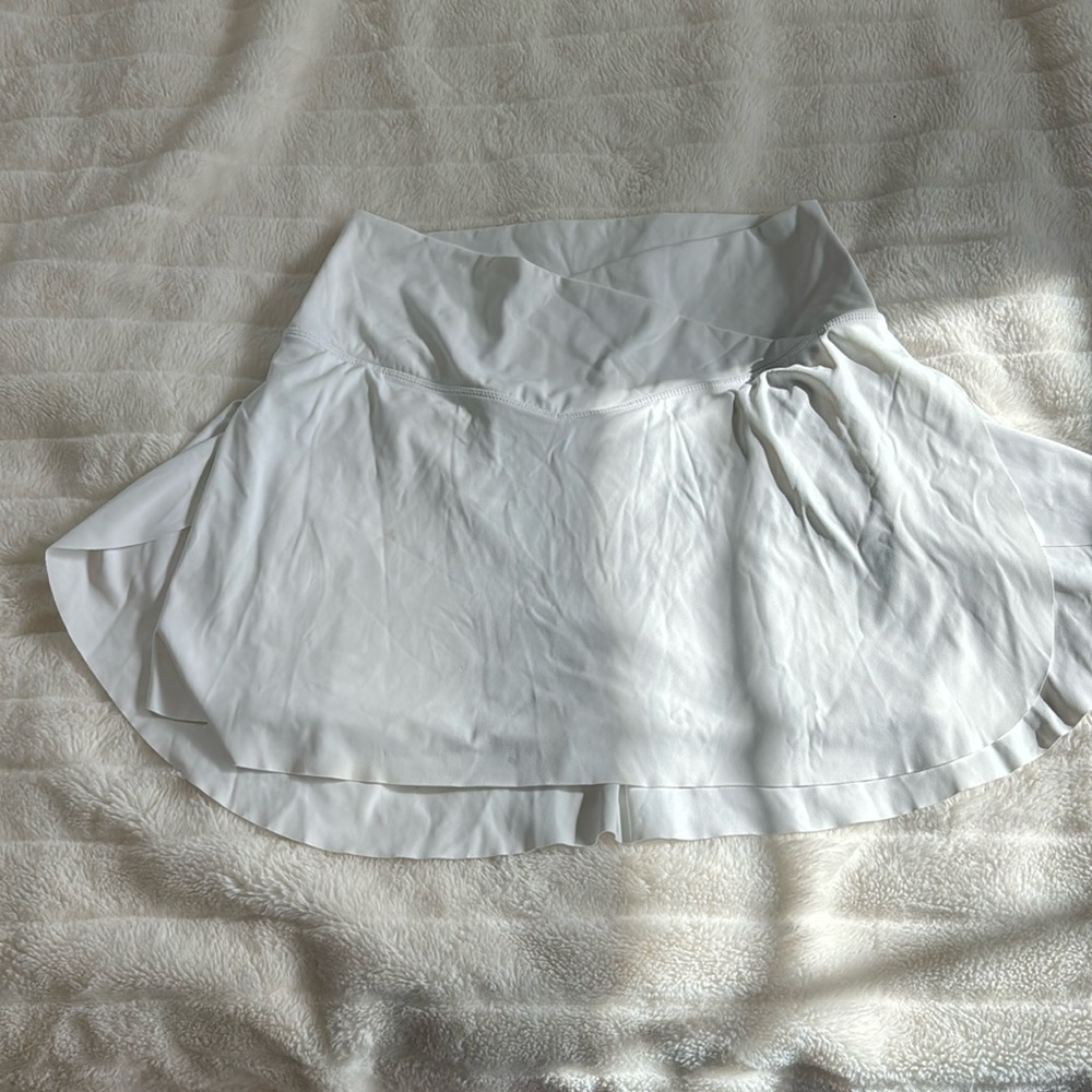 White athletic tennis skirt with built-in spandex and pocket with cross waste
